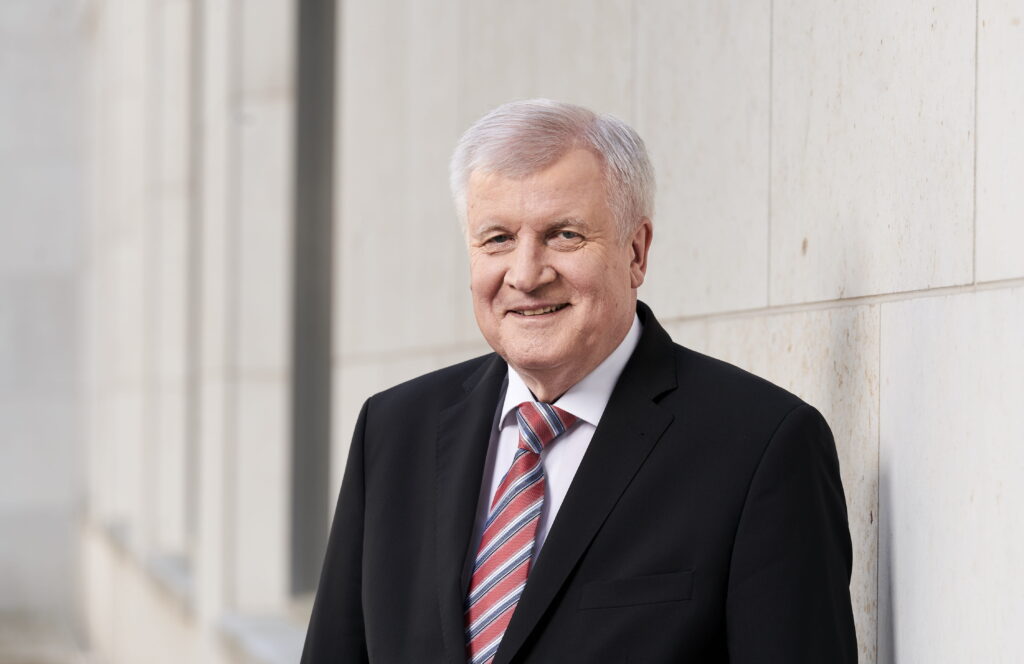 Bundesinnenminister Horst Seehofer (CSU) lehnt an an einer Wand.