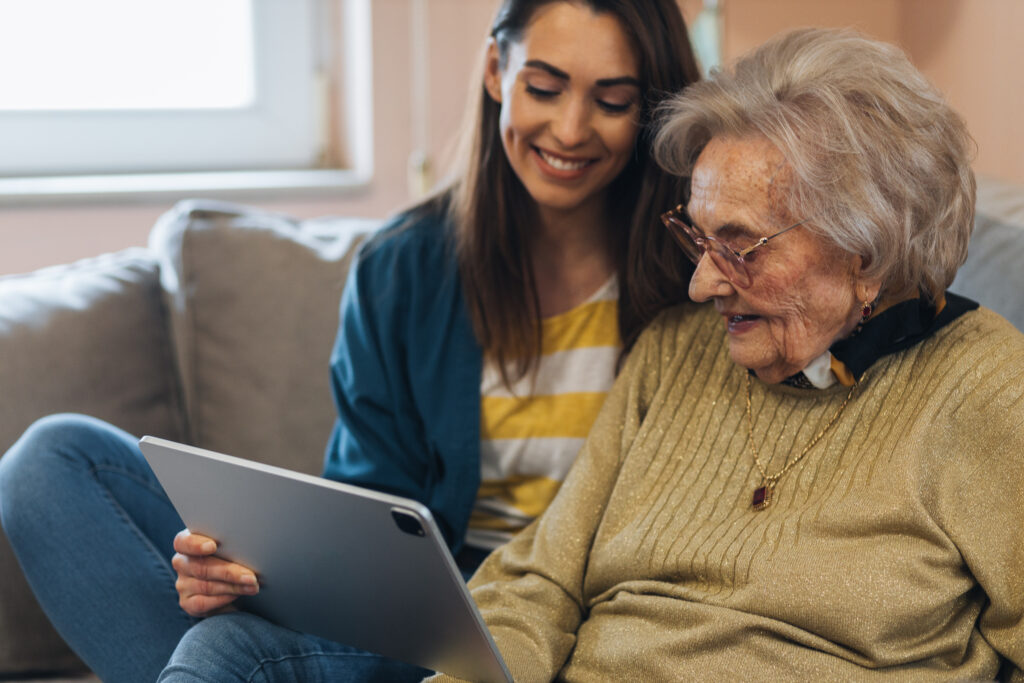 Eine junge und eine alte Frauen schauen auf ein Tablet
